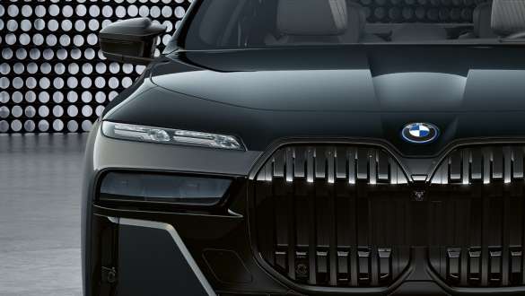 Upečatljiv prednji dizajn BMW M760e xDrive Sedan G70 Poklopac motora i prednje rešetke sa M logotipom BMW M760e xDrive Sedan G70 BMW Individual dvonijansna Black Sapphire metalik boja karoserije BMW Individual Dravite siva metalik boja krupni plan