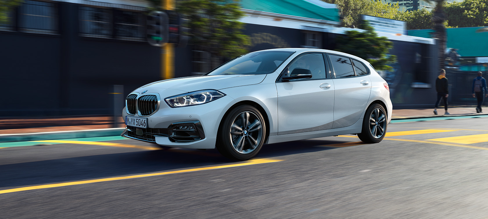 BMW serije 1 Model Sport Line, tročetvrtinski bočni pogled. BMW serije 1 Model Sport Line u boji Mineral White metliziranoj, tročetvrtinski bočni pogled, u vožnji.