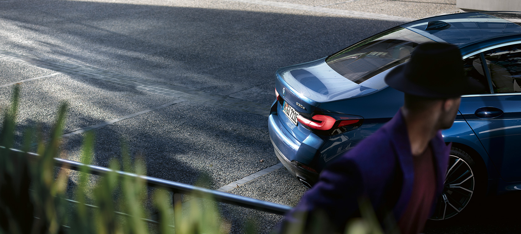 Čovek stoji iza parkiranog BMW BMW Serija 5 Sedan G30 BMW Serija 5 Sedan G30 fejslift 2020 čovek stoji iza parkiranog BMW