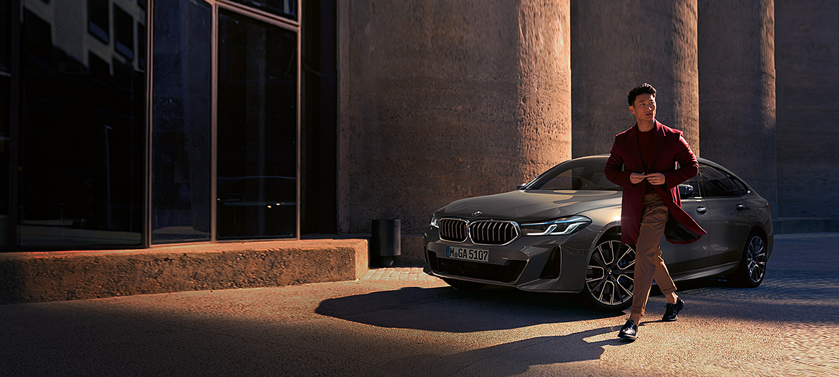 BMW Serija 6 Gran Turismo 640i xDrive G32 2020 Bernina siva boja, čovek ispred BMW-a, tročetvrtinski prednji prikaz nepomičnog vozila