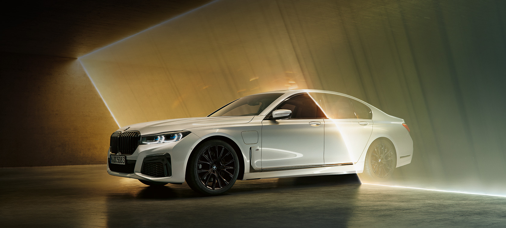 BMW Serije 7 Sedan, beli, tročetvrtinski pogled spreda BMW Serije 7 Sedan: beli BMW u tročetvrtinskom pogledu spreda okružen zracima svetla