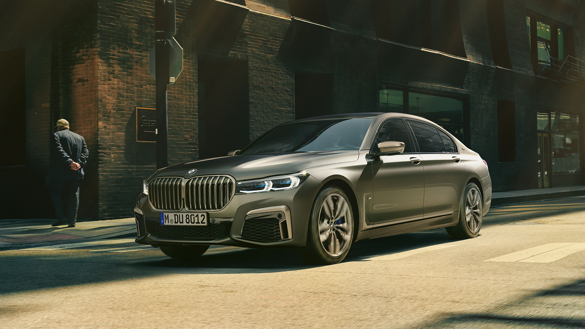 BMW M760Li xDrive u urbanom okruženju BMW M760Li xDrive u pogledu spreda i sa strane dok vozi po ulici u urbanom okruženju