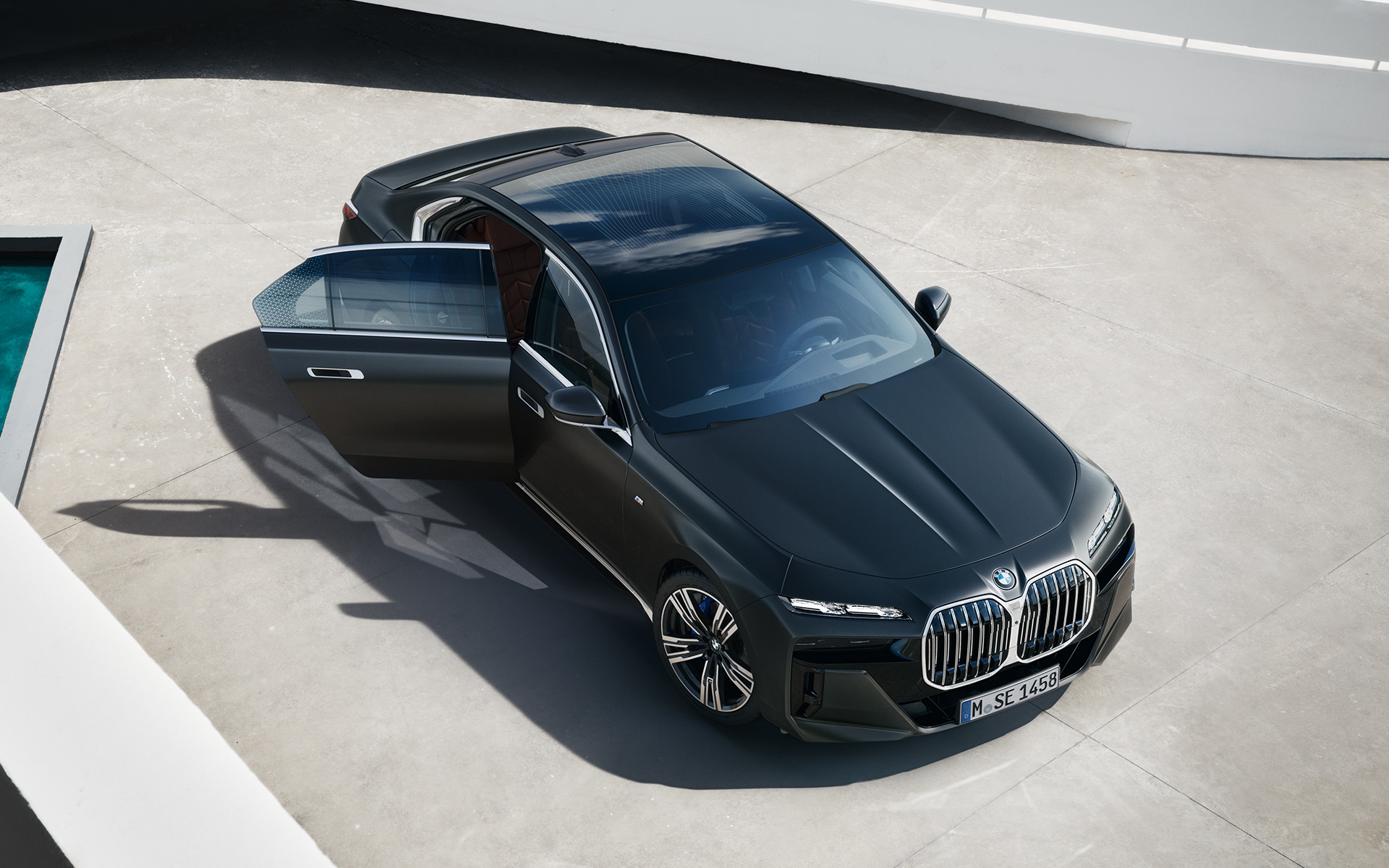Ptičija perspektiva BMW Serije 7 Sedan G70 ICE 740i M sports paket Frozen Deep sive metalik boje BMW Serije 7 Sedan G70 ICE 740i M sports paket Frozen Deep sive metalik boje ptičija perspektiva sa otvorenim vratima putnika
