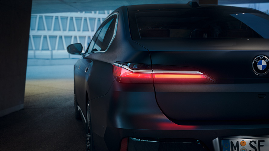 BMW Serije 7 Sedan G70 ICE 740i M sports paket Frozen Deep sive metalik boje zadnji prikaz vozila sa upaljenim crvenim zadnjim svetlima u tunelu