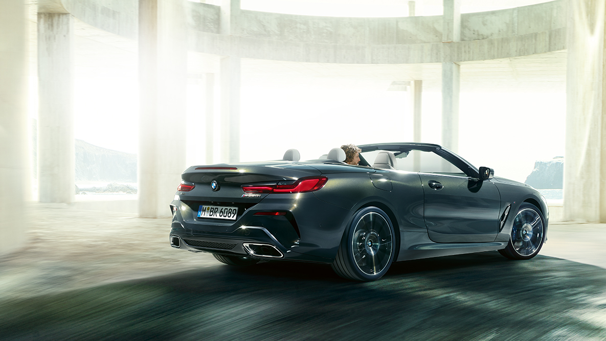 BMW M850i xDrive sa otvorenim mekim krovom, u vožnji, pogled sa strane. BMW M850i xDrive sa otvorenim mekim krovom, u vožnji, pogled sa strane