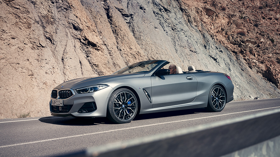 BMW Serije 8 Cabrio G14 LCI Facelift 2022 BMW Individual Frozen Pure sive metalik boje bočni prikaz vozila sa otvorenim mekanim krovom tokom brdske vožnje