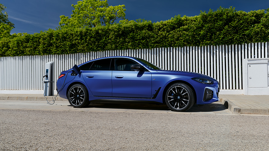 BMW i4 M50 G26 2021 BMW Individual Frozen Portimao plava metalik boja bočni prikaz vozila koji je priključen na uređaj za punjenje električnom energijom