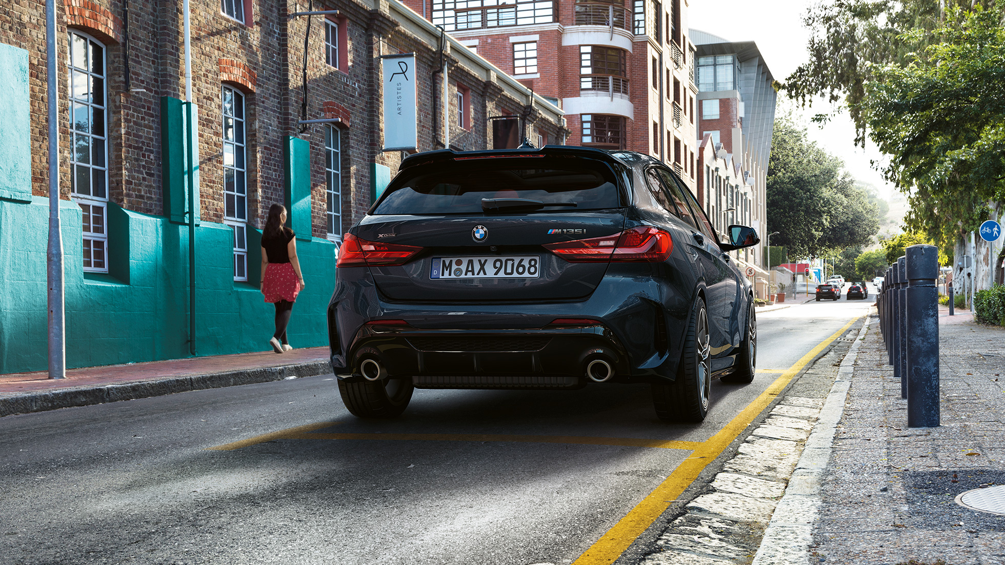 BMW M135i xDrive, pogled otpozadi. BMW M135i xDrive u boji Black Sapphire metaliziranoj, pogled otpozadi u parkiranju.