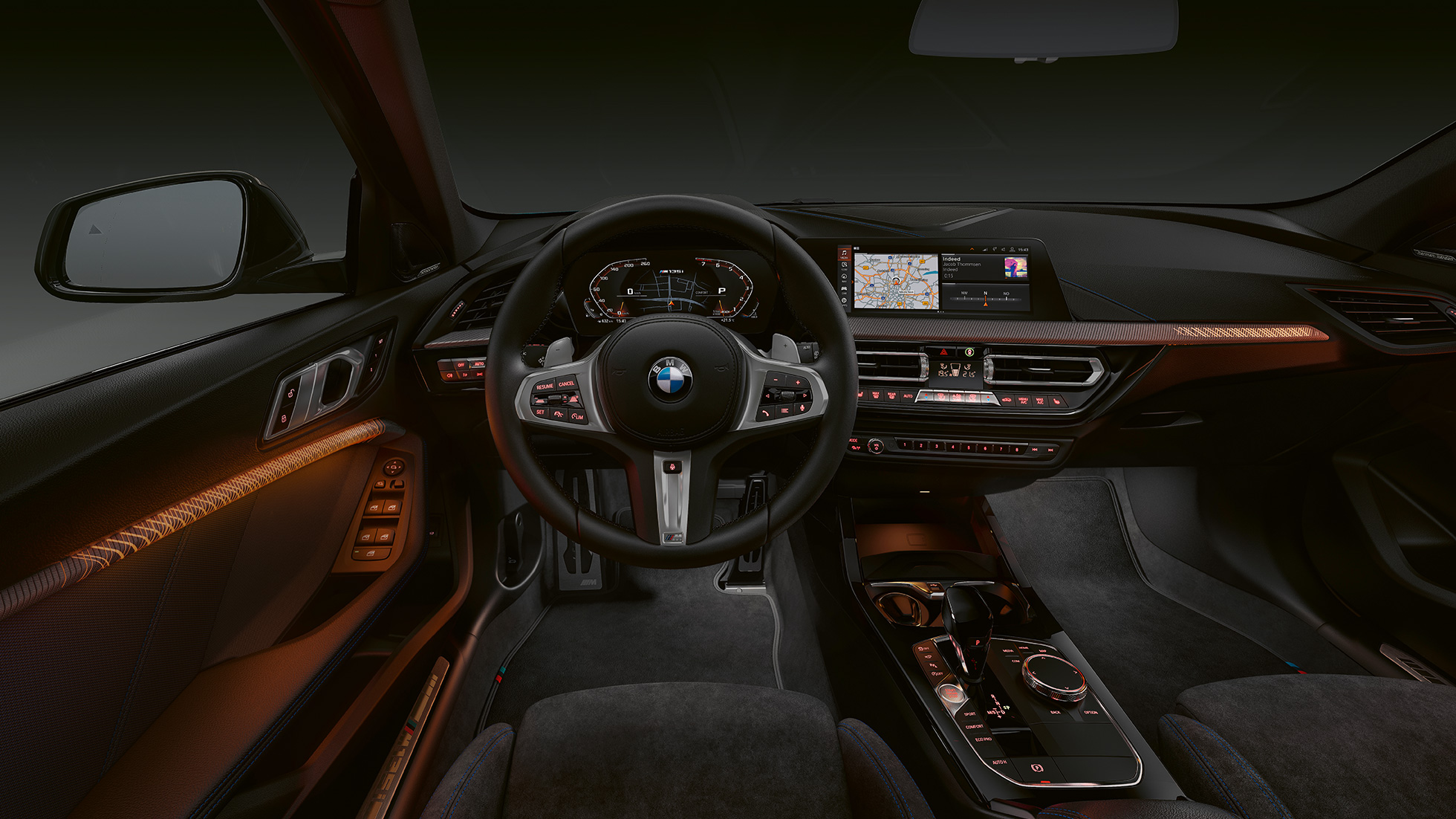 BMW M135i xDrive, kabina. Vrhunski enterijer modela BMW M135i xDrive sa osvetljenim zvršnim elementima unutrašnjih ukrasnih lajsni.
