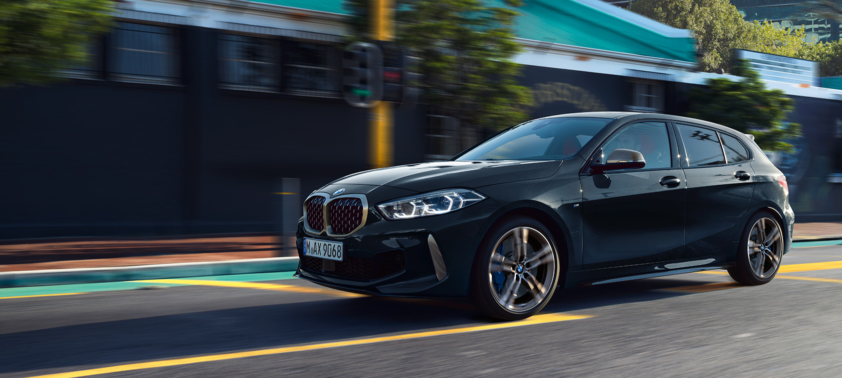Sasvim nov BMW M135i xDrive Sasvim nov BMW M135i xDrive u boji Black Sapphire metaliziranoj, tročetvrtinski bočni pogled u vožnji.