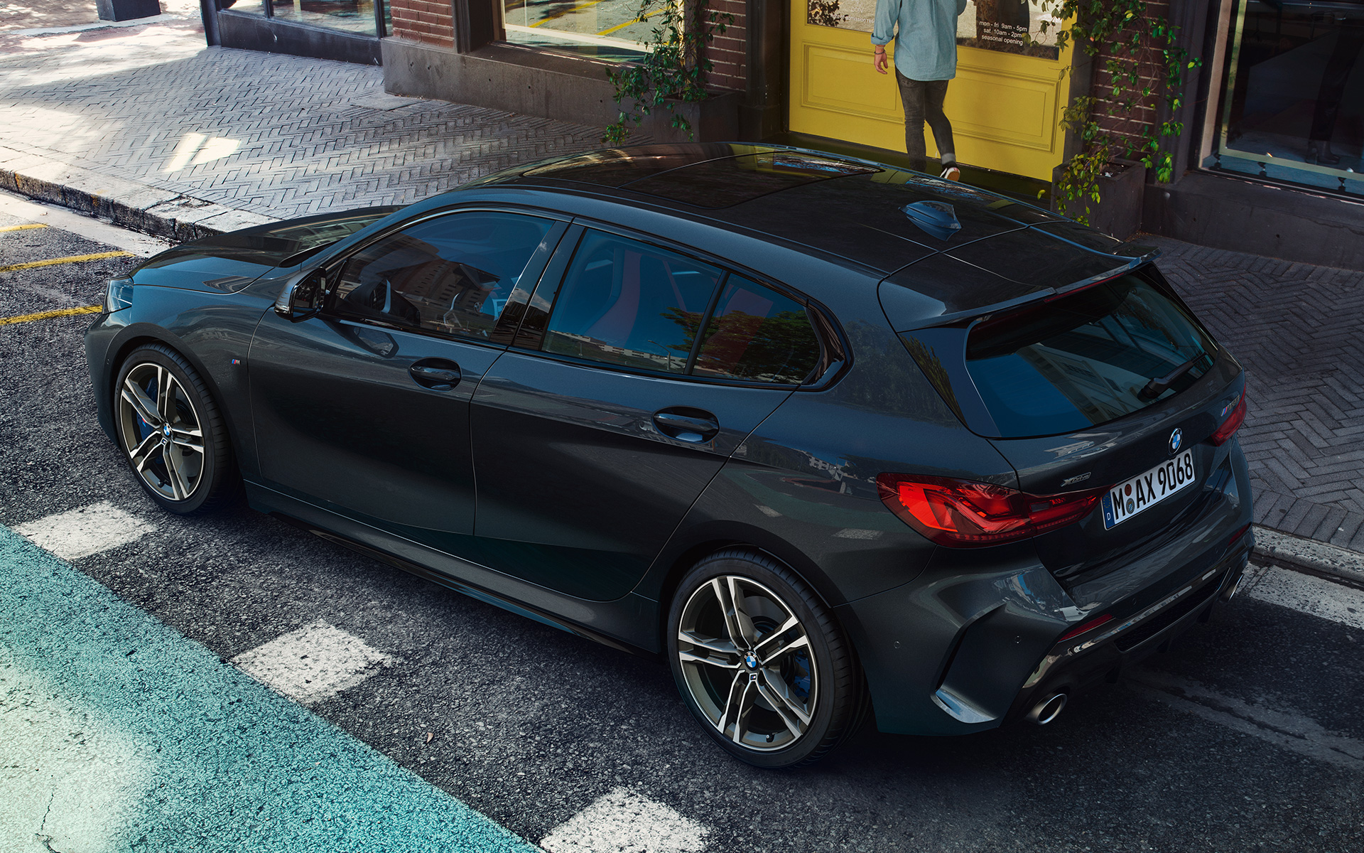 BMW M135i xDrive (F40) u Black Sapphire metalik boji, bočni prikaz iz ptičje perspektive