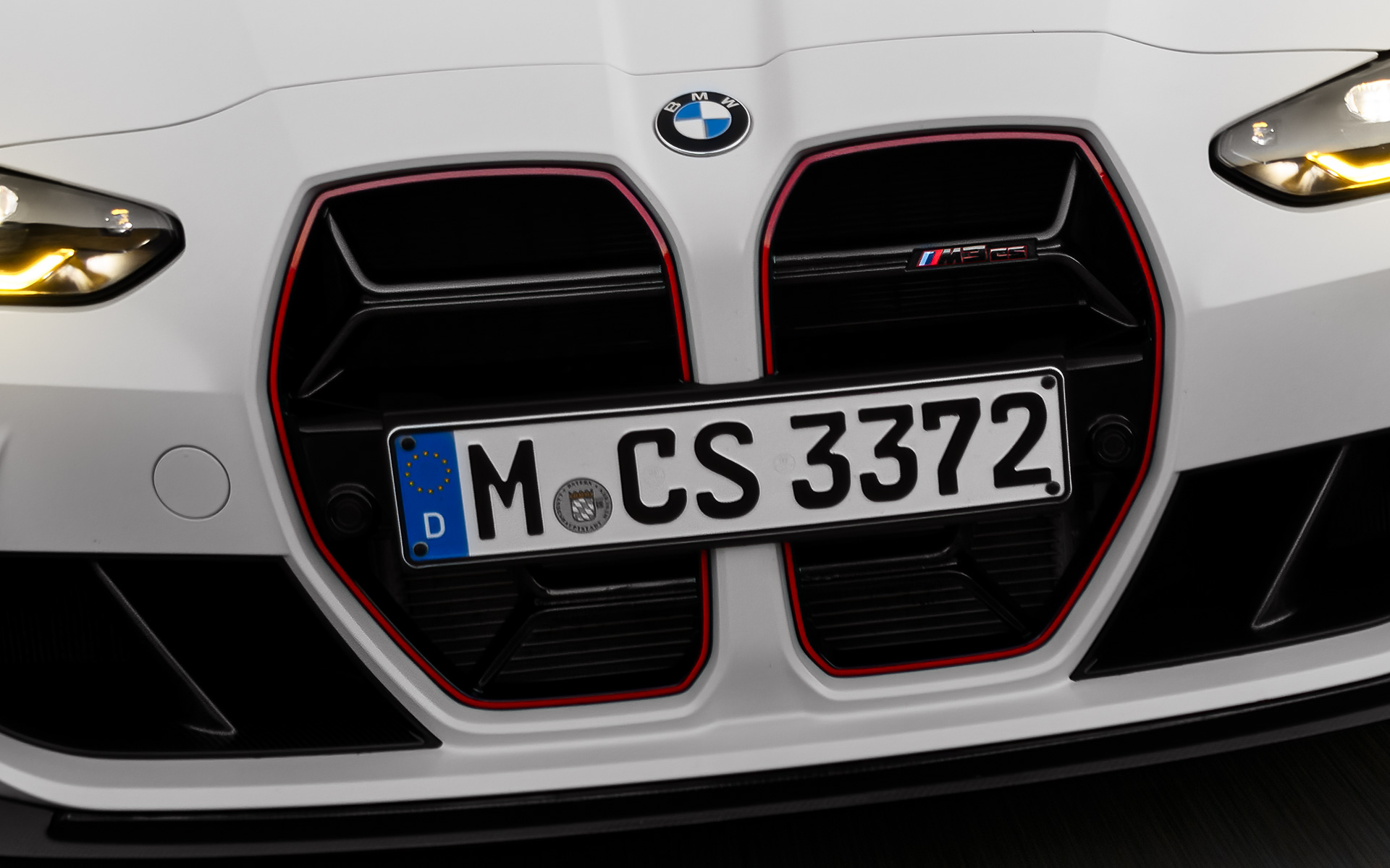 CS specifična prednja rešetka u crnoj boji sa crvenim specijalnim potpisom specifičnim za model BMW CS G80 BMW M3 CS G80 CS specifična prednja rešetka u crnoj boji sa crvenim specijalnim potpisom specifičnim za model prednji prikaz vozila tokom vožnje