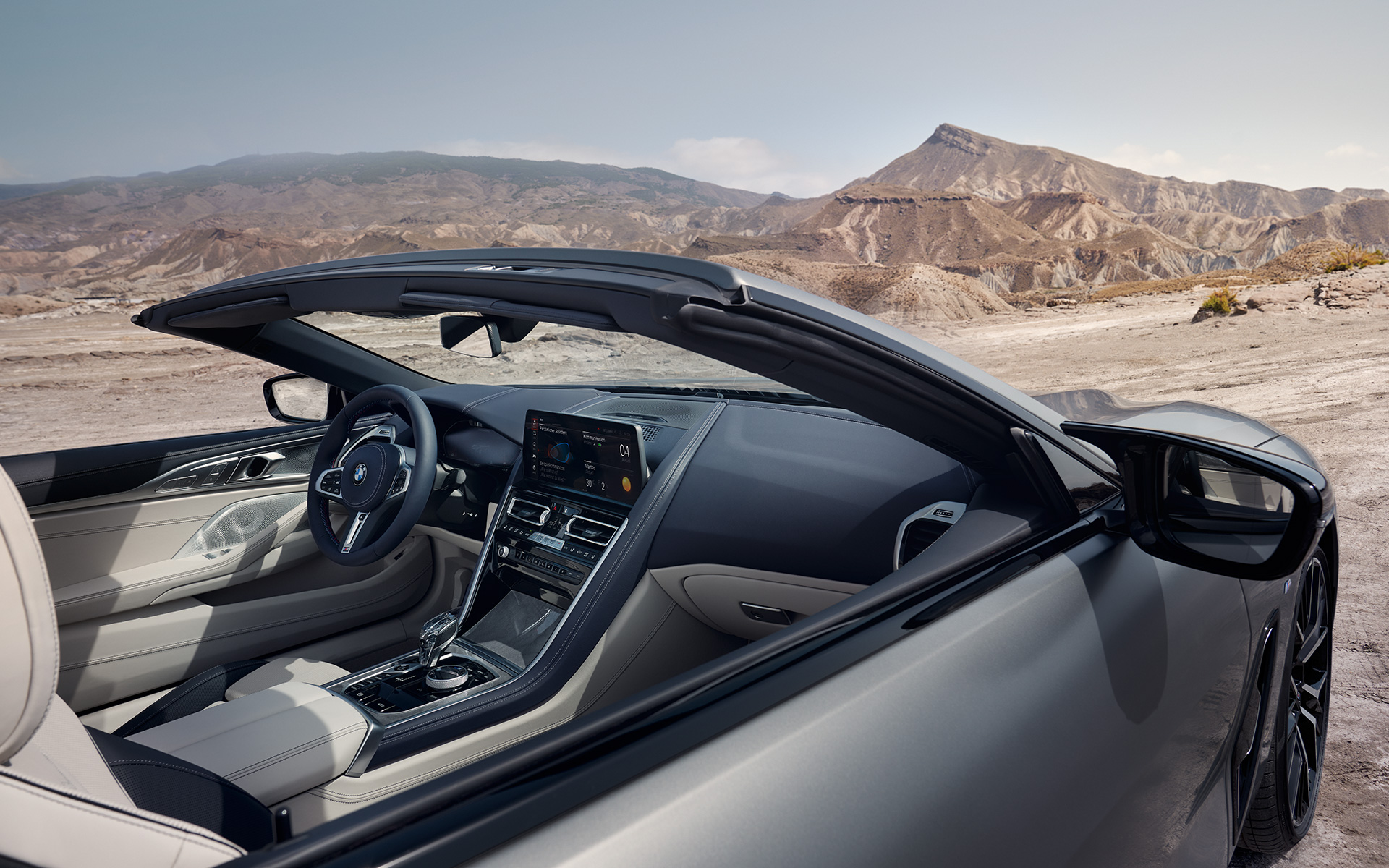 Unutrašnjost BMW M850i xDrive Kabriolet G14 LCI Facelift 2022 BMW M850i xDrive Kabriolet G14 LCI Facelift 2022 BMW Individual Frozen Pure siva metalik boja pogled k enterijeru sa otvorenim mekanim krovom