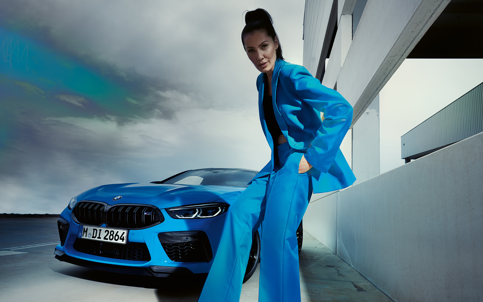 BMW M8 Competition Coupé F92 LCI 2022 tročetvrtinski prednji prikaz BMW M8 Competition Coupé F92 LCI Facelift 2022 Daytona Beach plave uni boje tročetvrtinski prednji prikaz iz niskog ugla sa modelom u plavom odelu