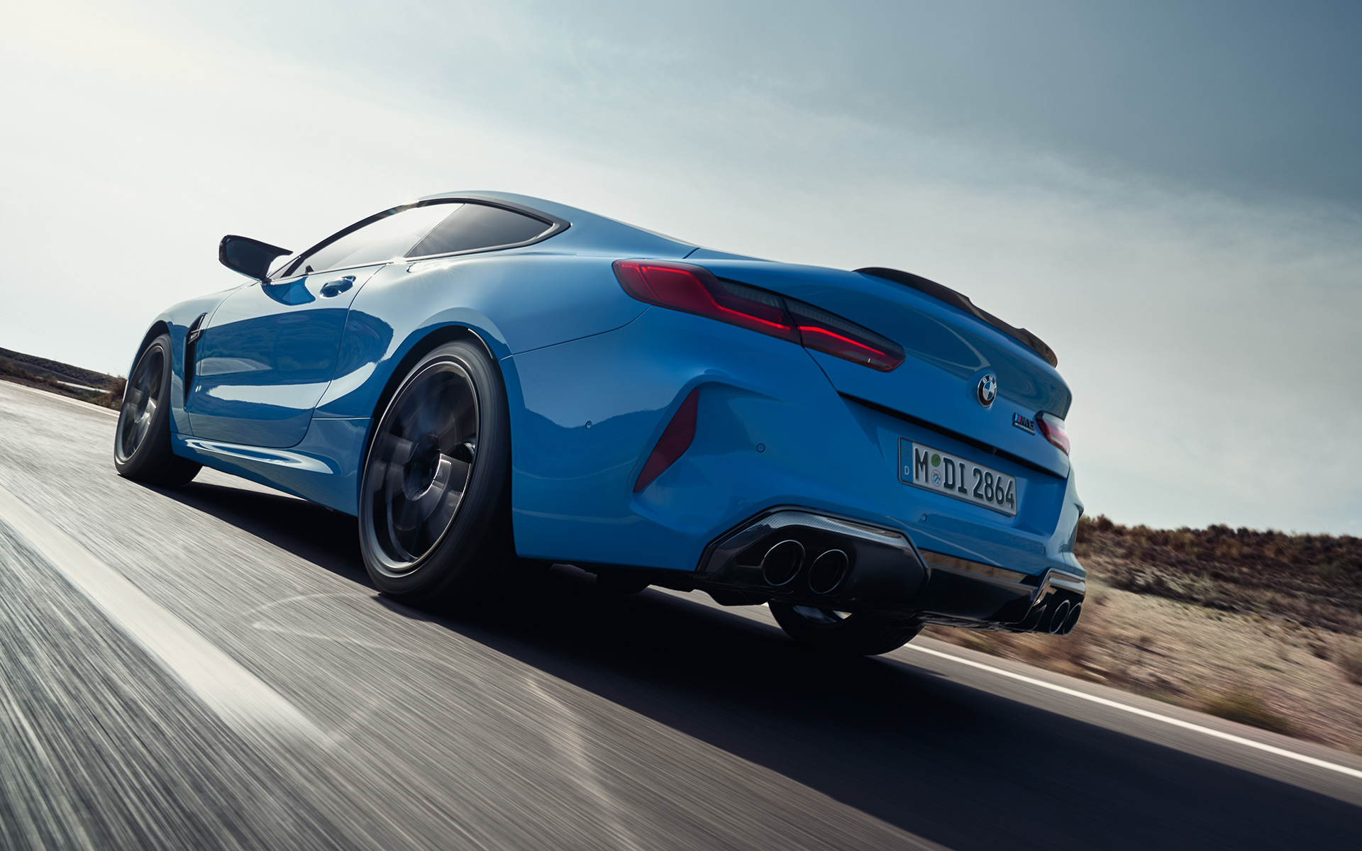 BMW M8 Competition Coupé F92 LCI 2022 tročetvrtinski zadnji prikaz vozila tokom vožnje BMW M8 Competition Coupé F92 LCI Facelift 2022 Daytona Beach plave uni boje tročetvrtinski zadnji prikaz vozila na autoputu