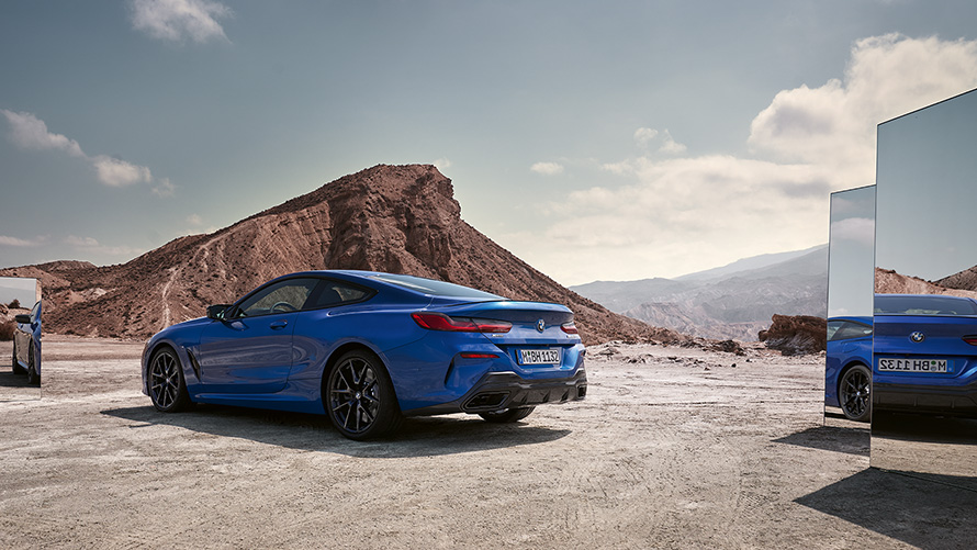 BMW M850i xDrive Coupé G15 LCI Facelift 2022 M Portimao plave metalik boje zadnji prikaz parkiranog vozila sa fokusom na retrovizore