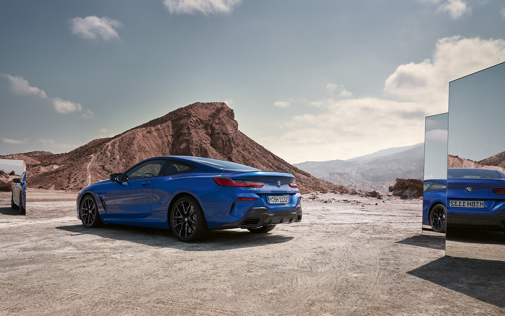 BMW M850i xDrive Coupé G15 LCI Facelift 2022 zadnji prikaz parkiranog vozila BMW M850i xDrive Coupé G15 LCI Facelift 2022 M Portimao plave metalik boje zadnji prikaz parkiranog vozila sa fokusom na retrovizore