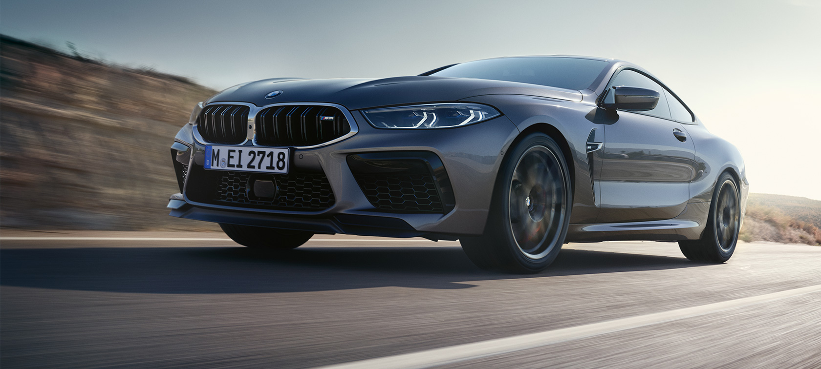 BMW M8 Coupé F92 LCI Facelift 2022 tročetvrtinski bočni prikaz vozila u toku vožnje BMW M8 Coupé F92 LCI Facelift 2022 Skyscraper sive metalik boje tročetvrtinski bočni prikaz iz niskog ugla