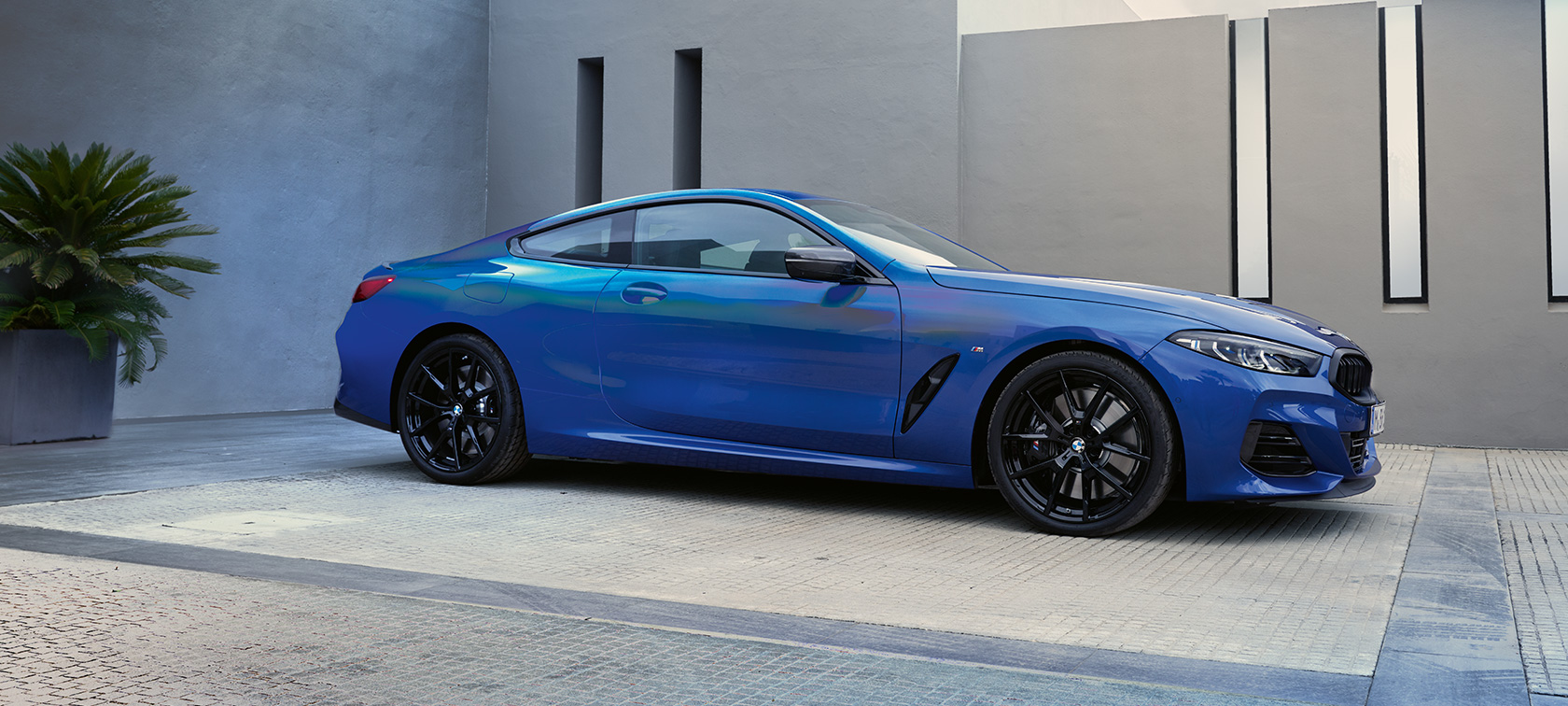 Bočni prikaz BMW M850i xDrive Coupé G15 LCI Facelift 2022 BMW M850i xDrive Coupé G15 LCI 2022 M Portimao plave metalik boje bočni prikaz vozila parkiranog ispred zgrade