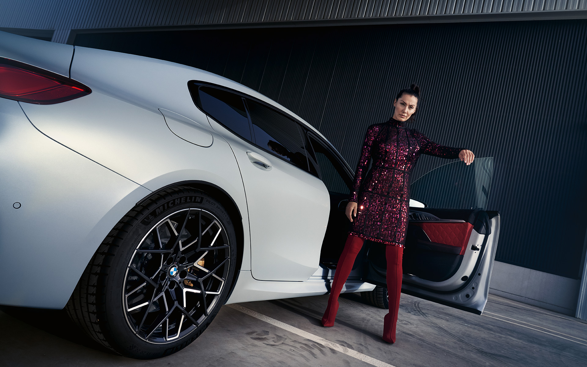 BMW M8 Competition Gran kupe F93 LCI 2022 tročetvrtinski zadnji prikaz iz niskog ugla s modelom BMW M8 Competition Gran kupe F93 LCI Facelift 2022 BMW Individual Frozen Brilliant bela metalik boja tročetvrtinski zadnji prikaz s modelom iz niskog ugla