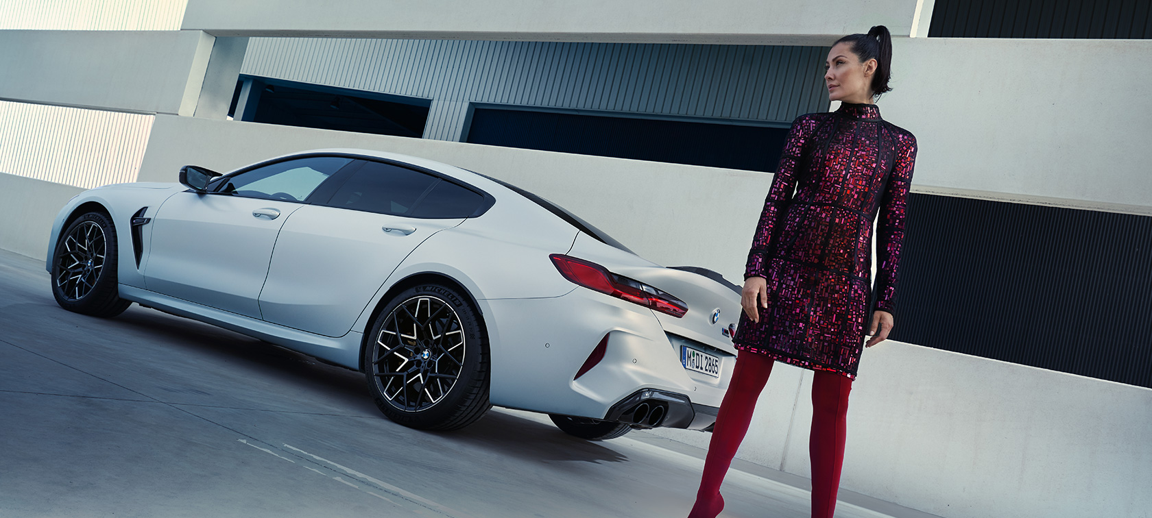 Tročetvrtinski zadnji prikaz BMW M8 Competition Gran kupe F93 LCI 2022 BMW M8 Competition Gran kupe F93 LCI Facelift 2022 BMW Individual Frozen Brilliant bela metalik boja tročetvrtinski zadnji prikaz s modelom koja stoji pored vozila