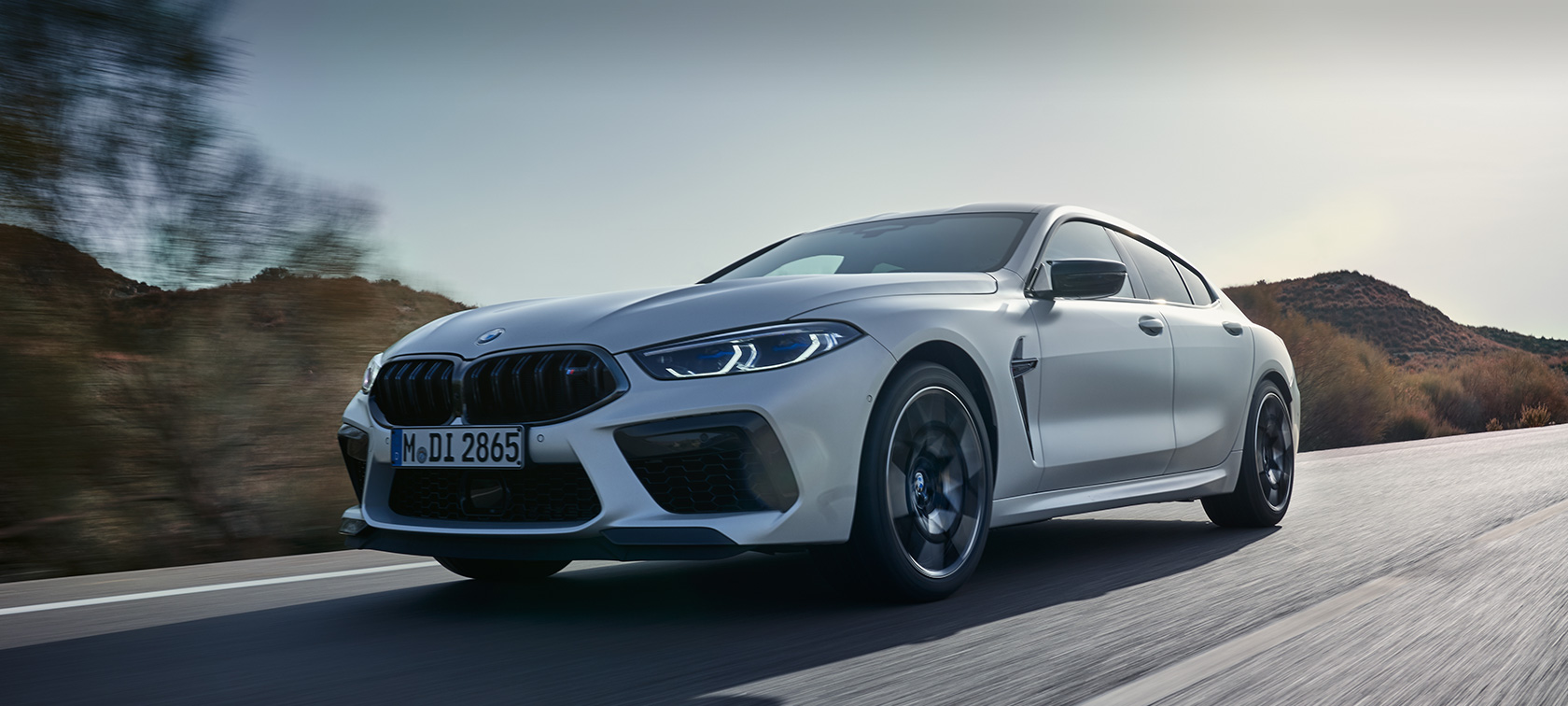 BMW M8 Competition Gran kupe F93 LCI Facelift 2022 BMW Individual Frozen Brilliant bela metalik boja tročetvrtinski prednji prikaz tokom vožnje