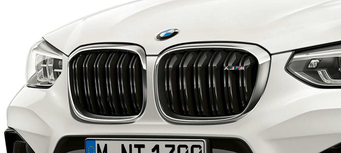 BMW X3 M, M prednja rešetka. BMW X3 M u boji Alpine White, eksterijer, spreda, M prednja rešetka sa hromiranim detaljima i oznakom modela.