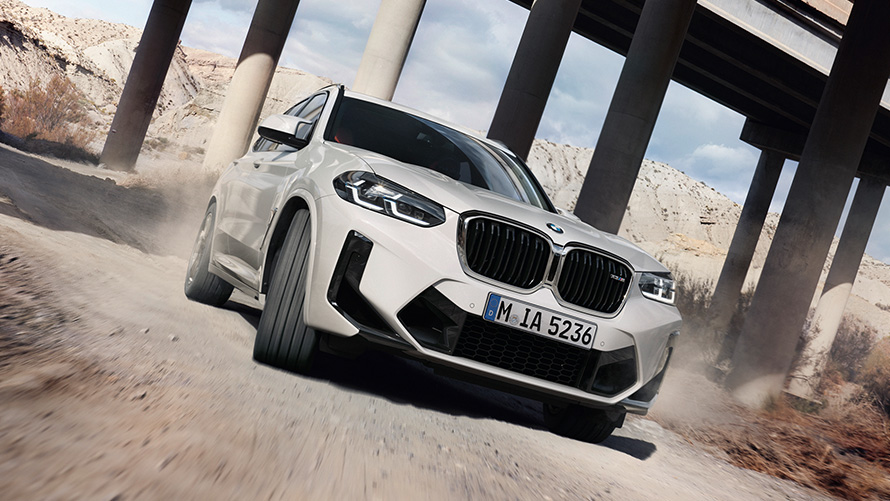 BMW X3 M F97 LCI Facelift 2021 Alpine bela boja, tročetvrtinski prednji prikaz vozila koji ulazi u krivinu