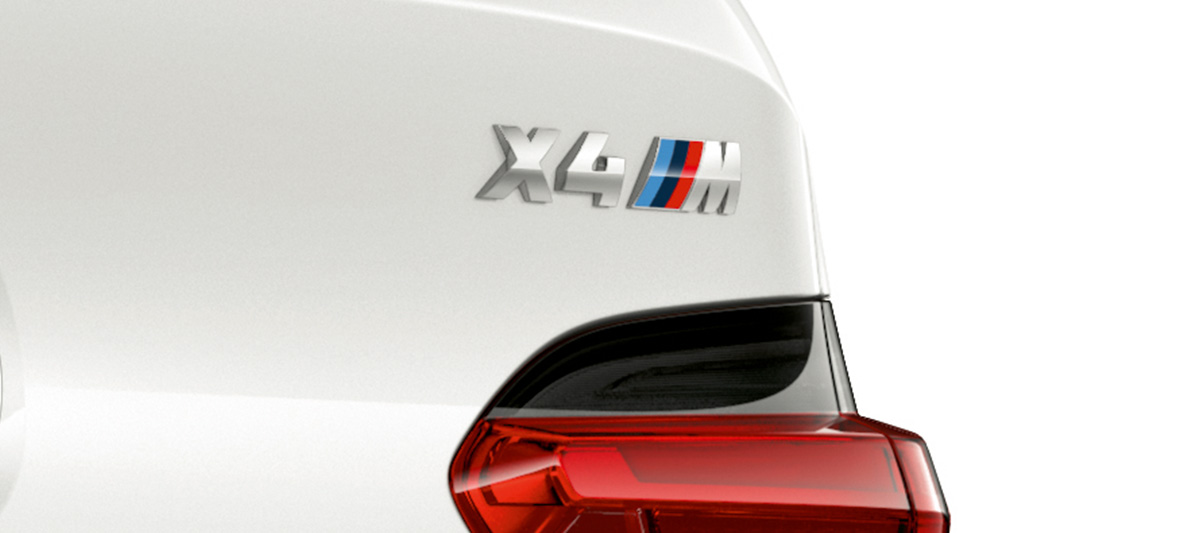 BMW X4 M, oznaka modela. BMW X4 M in Alpine White, eksterijer, izbliza otpozadi sa oznakom modela.