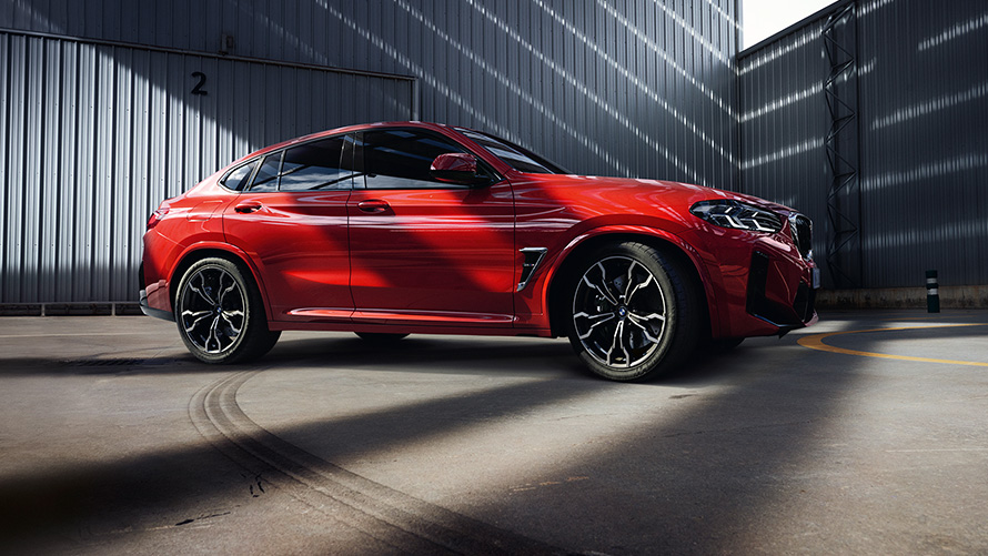 BMW X4 M F98 LCI Facelift 2021 Toronto crvene metalik boje bočni prikaz vozila ispred zgrade fabrike
