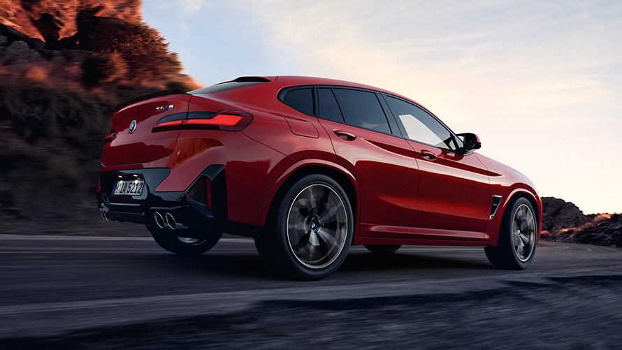 BMW X4 M F98 LCI Facelift 2021 Toronto crvene metalik boje tročetvrtinski stražnji prikaz vozila na putu