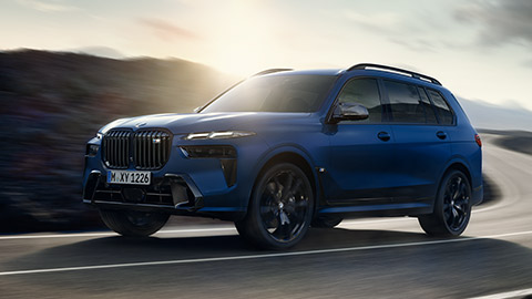 BMW X7 M Automobile G07 MP three-quarter rear view driving on the street BMW X Series BMW X7 M Automobile G07 MP three-quarter rear view driving on the street