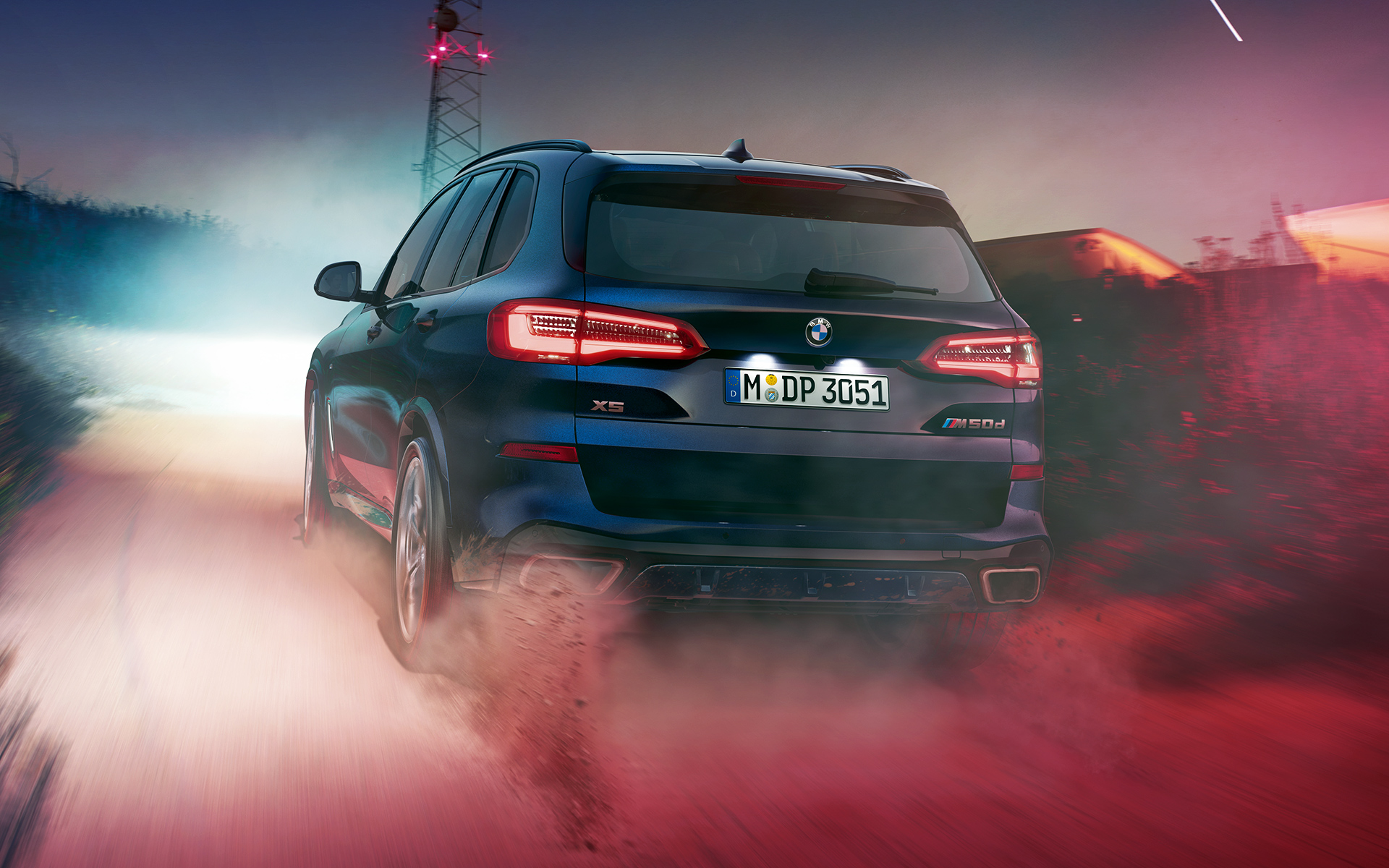 BMW X5 M50d pozadi Zadnja strana modela BMW X5 M50d noću u gradskom okruženju