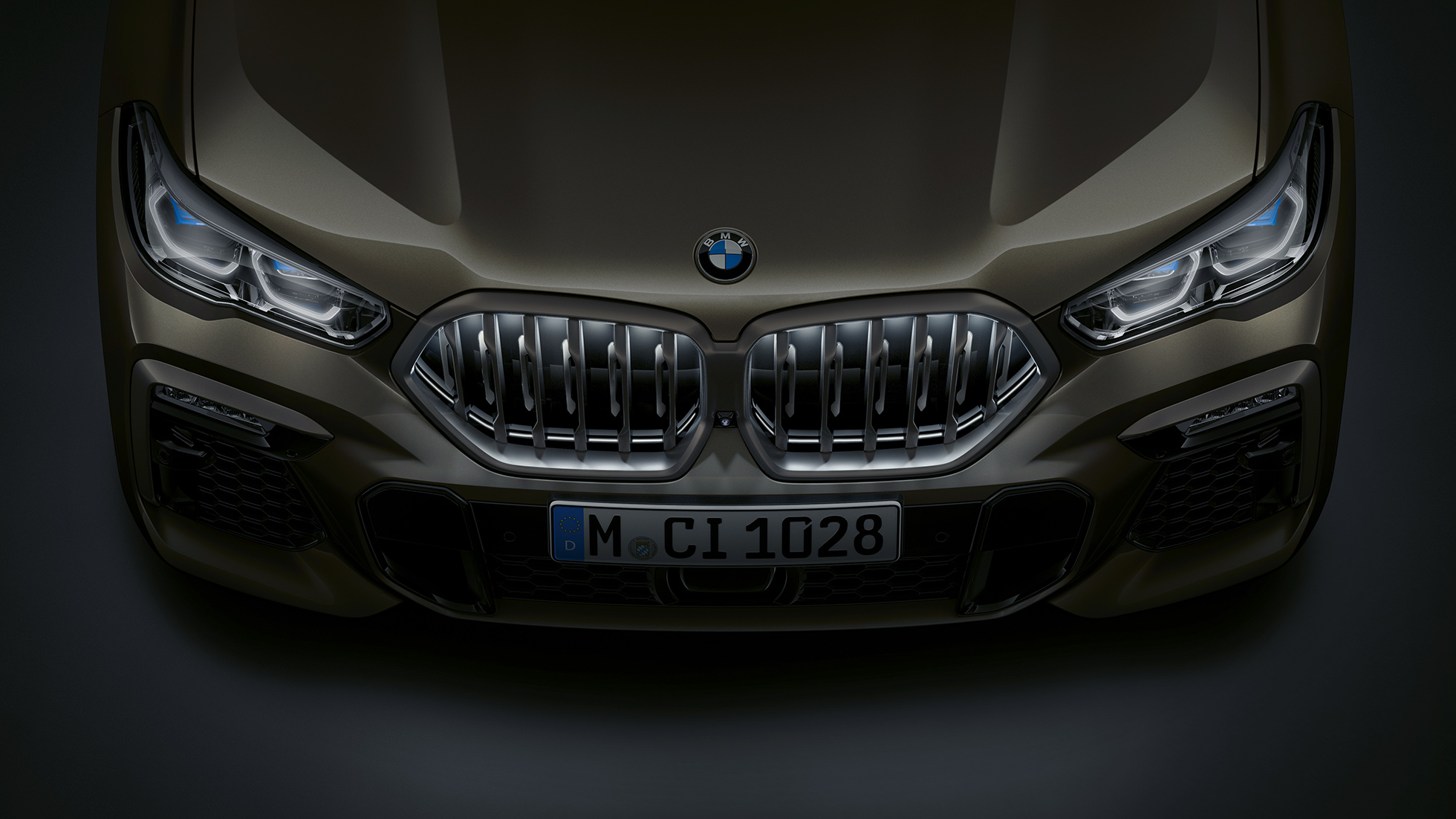 BMW X6 spreda. Pogled izbliza na prednju stranu BMW X6 sa BMW prednjom rešetkom „Iconic Glow“ iz ptičje perspektive.