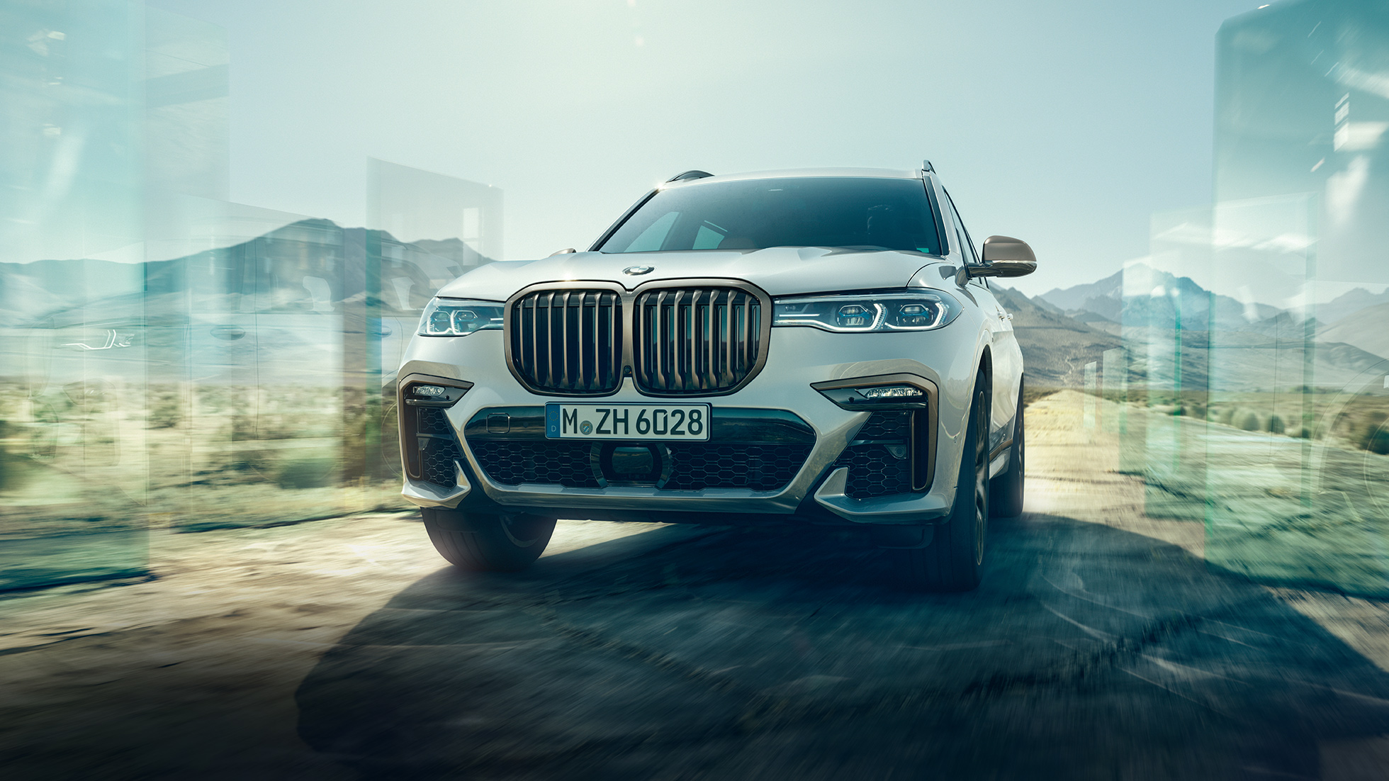 BMW X7 M50d, snimak iz niskog uglat BMW X7 M50d: snimak iskosa i iz niskog uga na kojem se vidi beli BMW X7 u vožnji