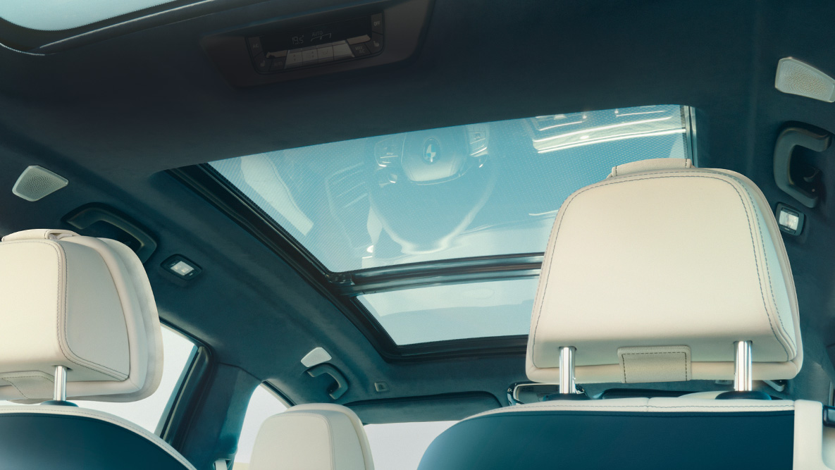 Panorama glass roof Pogled iz zadnjeg reda sedišta uvis prema panoramskom staklenom krovu sa pogledom na plavo nebi