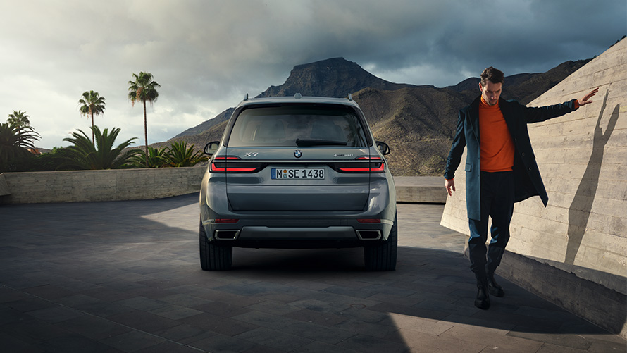 BMW X7 G07 LCI Zadnji prikaz Sparkling Copper siva metalik boja Pure Excellence dizajn BMW X7 G07LCI Zadnji prikaz s modelom s desne strane Sparkling Copper siva metalik boja Pure Excellence dizajn