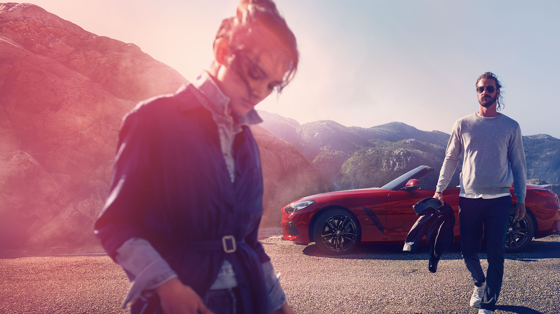 BMW Z4 Roadster ispred planinskog pejzaža Muškarac i žena i BMW Z4 Roadster ispred planinskog pejzaža