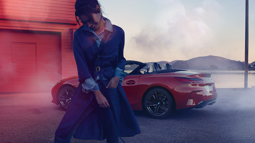 BMW Z4 M40i Roadster G29 sa otvorenim mekanim krovom BMW Z4 M40i Roadster G29 tročetvrtinski zadnji prikaz sa otvorenim mekanim krovom i ženom u prvom planu