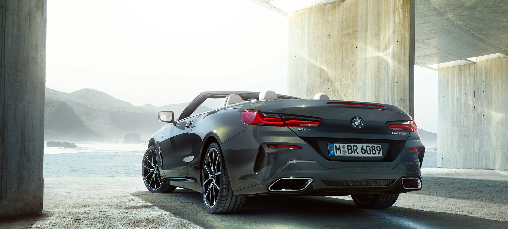BMW M850i xDrive Dravit Grey metalizirani, tročetvrtinski pogled sleva otpozadi