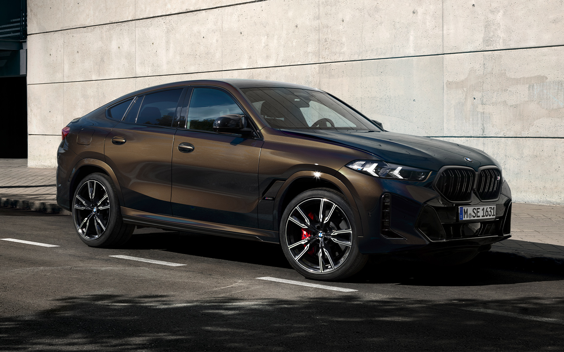 BMW X6 M60i G06 in Pyrite Brown metalik BMW X6 M60i G06 u BMW Individual Pyrite Brown metalik, 2/3 bočni prikaz na parkingu