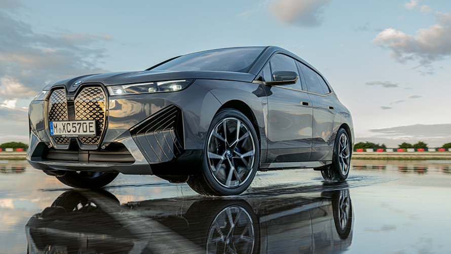BMW točkovi, tročetvrtinski prednji prikaz modela BMW iX (i20) na mokroj ulici BMW točkovi, tročetvrtinski prednji prikaz modela BMW iX (i20) na mokroj ulici