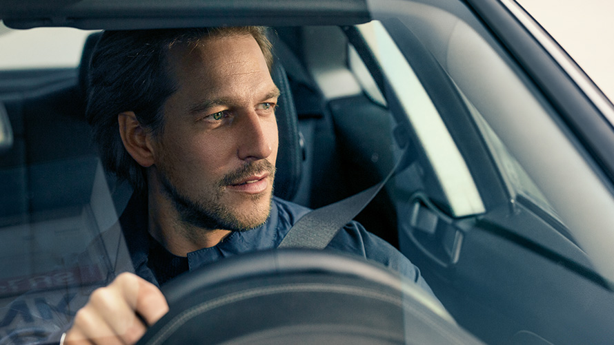 Čovek vozi BMW Čovek vozi BMW i gleda kroz vetrobran