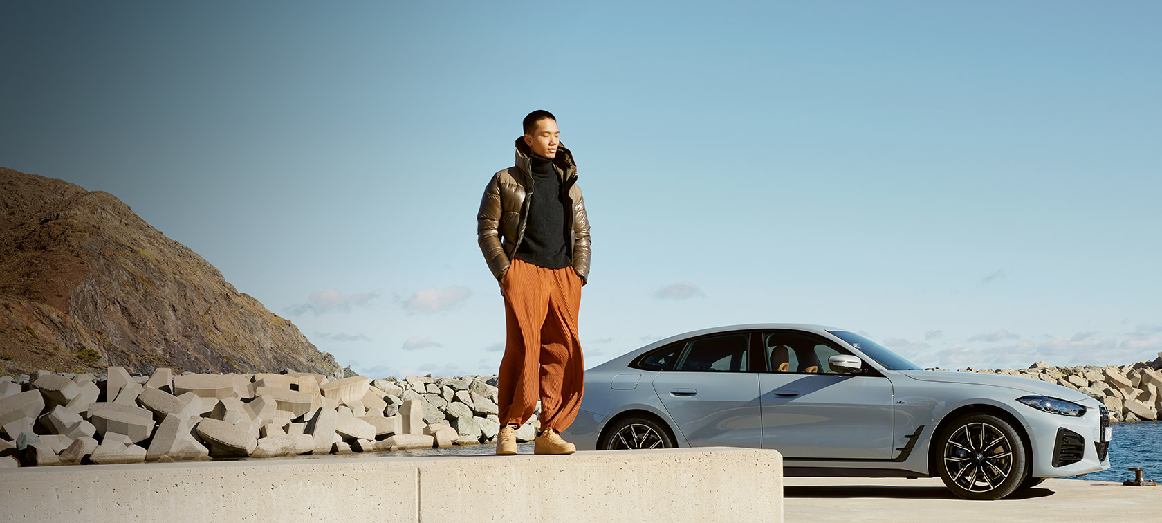 BMW Service Inclusive BMW Service Inclusive čovek ispred BMW-a i4 na obali