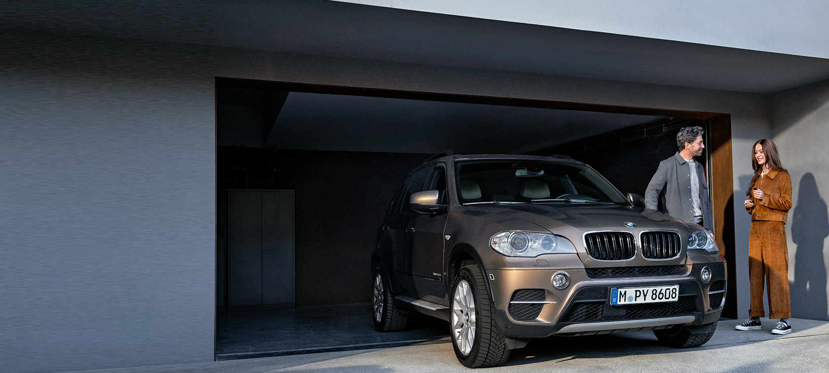 BMW Value Service BMW Value Service čovek i žena ispred garaže pored modela BMW X5