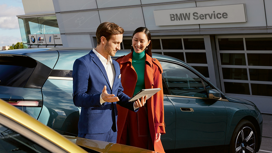 BMW Value Service BMW Service BMW Service Muškarac i žena ispred BMW iX-a kod BMW-vog servisnog partnera